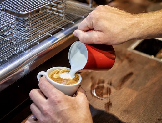 Jemand bereitet einen leckeren Milchkaffee im Cafe Salotto zu. 