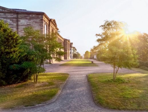 Die Sonne steht tief über dem imposanten Bauwerk der Neuen Galerie in Kassel.