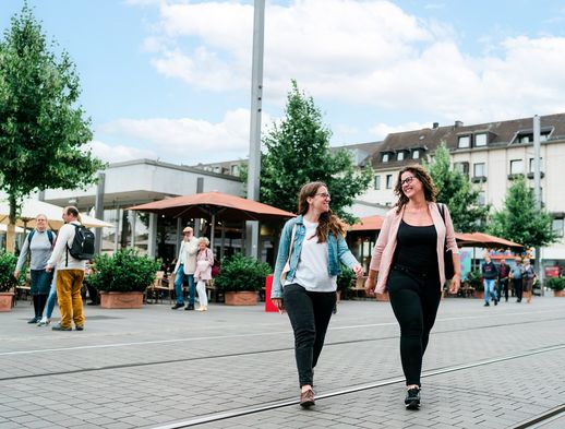 Zwei Frauen schlendern durch die Obere Königsstraße in Kassel und genießen die Zeit beim shoppen. 