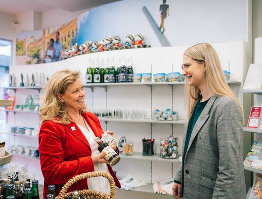 Die Mitarbeiterin Gabriela Thöne berät eine Kundin im Verkaufsraum der Tourist Information Kassel. 
