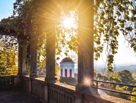 Die Sonne strahlt durch das Portal am Weinberg. 