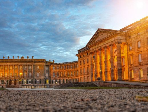 Blick auf Schloss Wilhelmshöhe von der Seite bei Sonnenuntergang