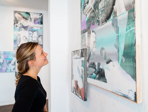 Junge Frau betrachtet Gemälde in der Galerie Rasch. 