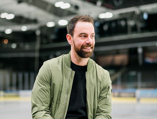 Derek Dinger sitzt auf der Bande in der Eissporthalle Kassel. 