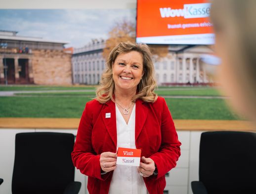 Gabriela Thöne zeigt in der Tourist Information Kassel eine Visitenkarte mit dem QR-Code für die Web-App visit.kassel.