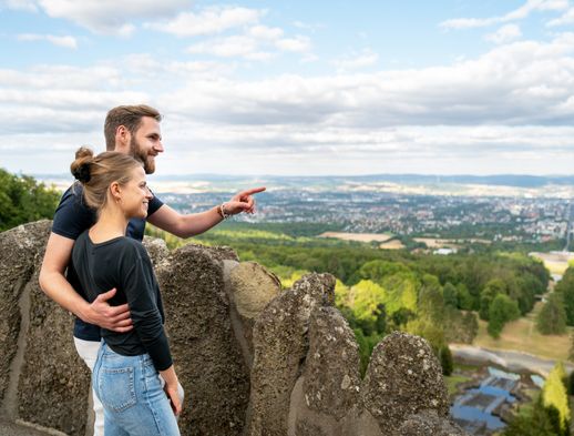 Zwei Personen schauen über den Bergpark Wilhelmshöhe in das Tal in dem Kassel liegt.