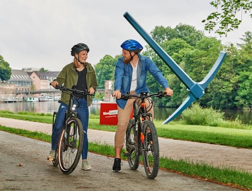 Ein junges Pärchen macht freudig eine Fahrradtour entlang der Fulda in Kassel. 